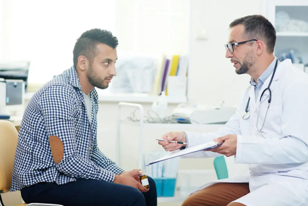 Patient speaking with doctor about treatment and warning signs during stages of relapse in recovery