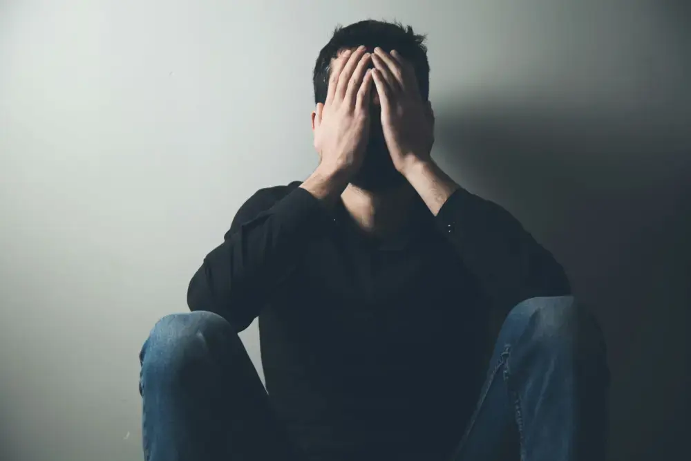 addiction-depression-treatment-new-jersey man sitting on the floor struggling with depression and addiction issues