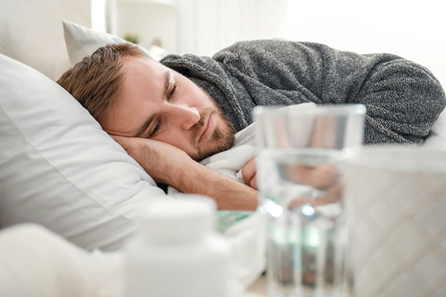 man lying in bed while struggling with oxycodone addiction